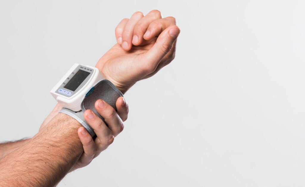 Portable wrist BP monitor on wrist—convenient but less accurate than upper-arm