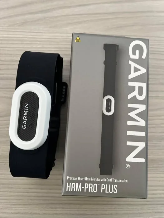 Garmin HRM-PRO Plus chest strap heart rate monitor next to the retail box.