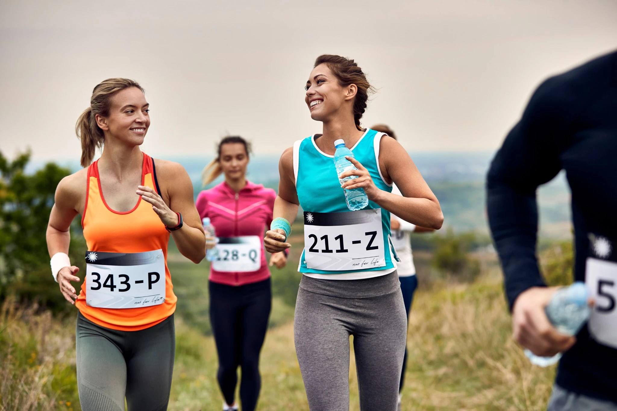 Female runners talking while running in an outdoor marathon event