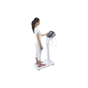 Person standing on a segmental bioelectrical impedance analyzer holding hand electrodes during body composition measurement.